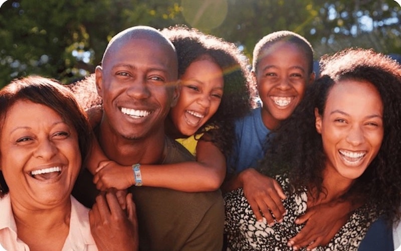 Photo of a family smiling wearing medicalert bracelets.