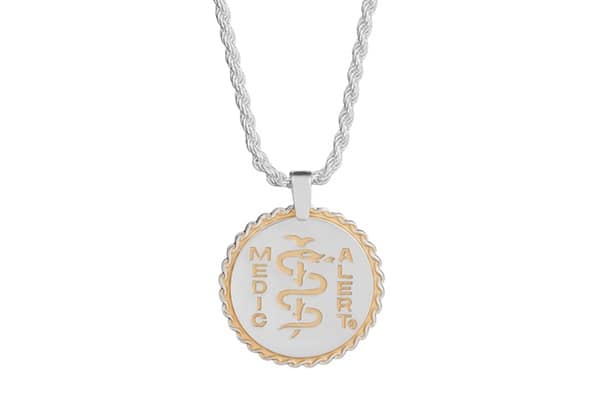 Round silver necklace on a silver chain with the MedicAlert logo embossed in gold.